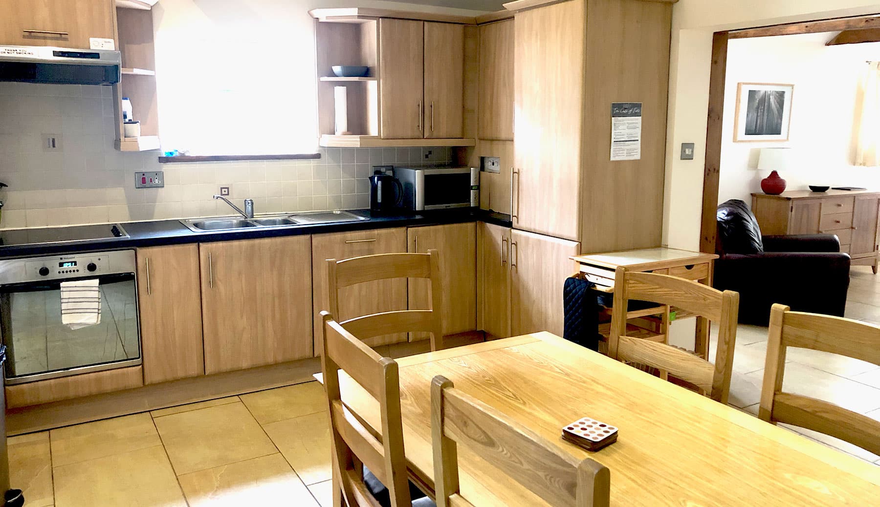 Kitchen-diner with oak units and a large oak dining table, looking through to the sitting room