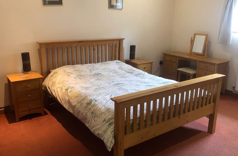 Double bedroom with a pine bed, bedside cabinets and a dressing table with a mirror